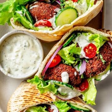 Falafel sandwiches on platter with tzatziki sauce