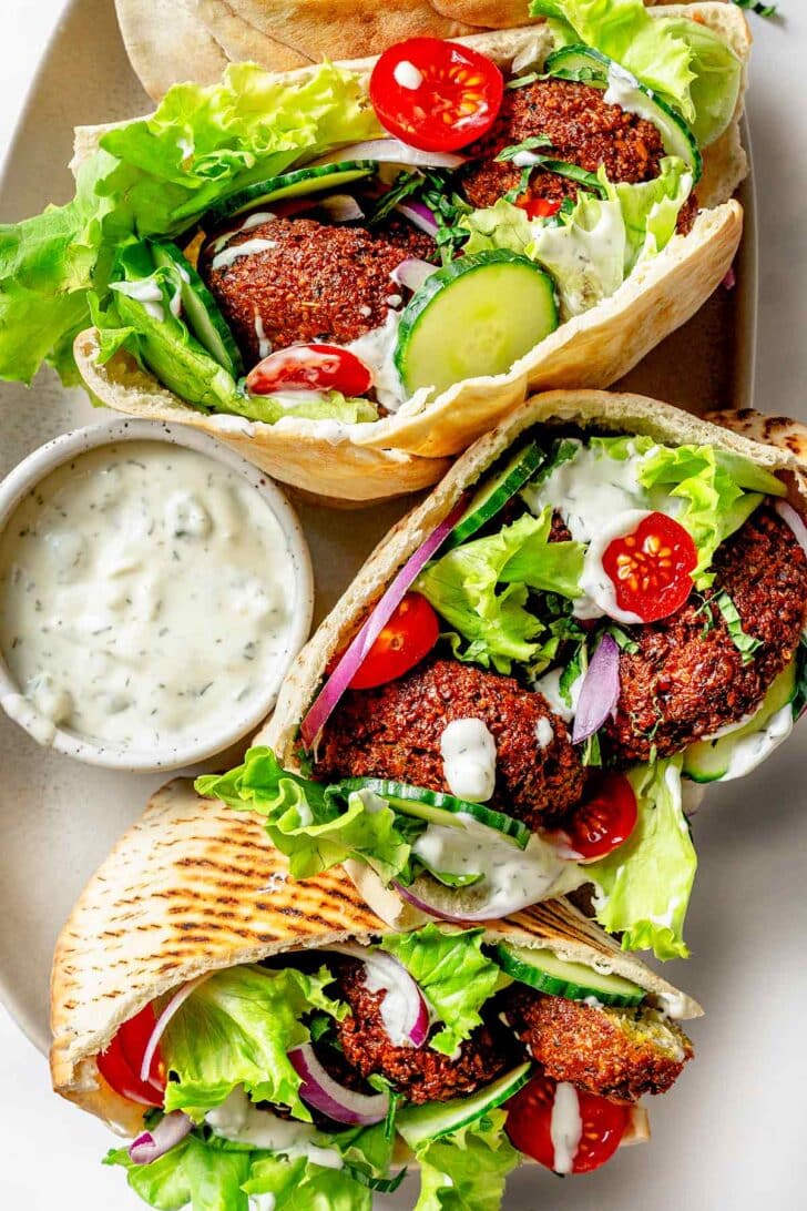 Falafel sandwiches on platter with tzatziki sauce