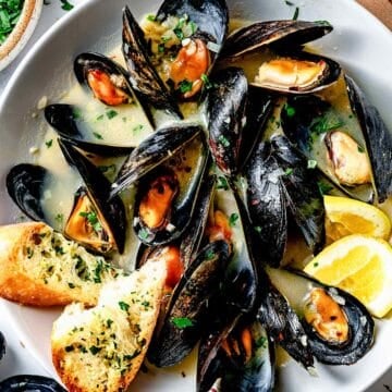 Steamed Mussels in bowl with garlic bread