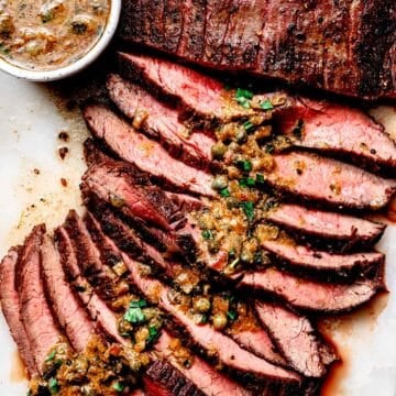 Pan-Seared Flank Steak with Mustard Caper Sauce on cutting board