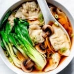 Wonton Soup with mushrooms and bok choy in bowl with spoon