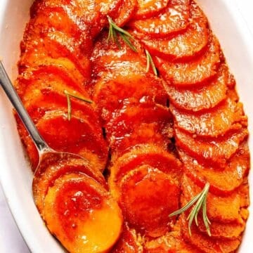 Candied Sweet Potatoes in baking dish with spoon
