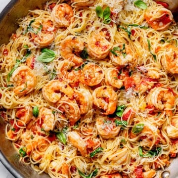 Shrimp Scampi Pasta with tomatoes with angel hair pasta in skillet