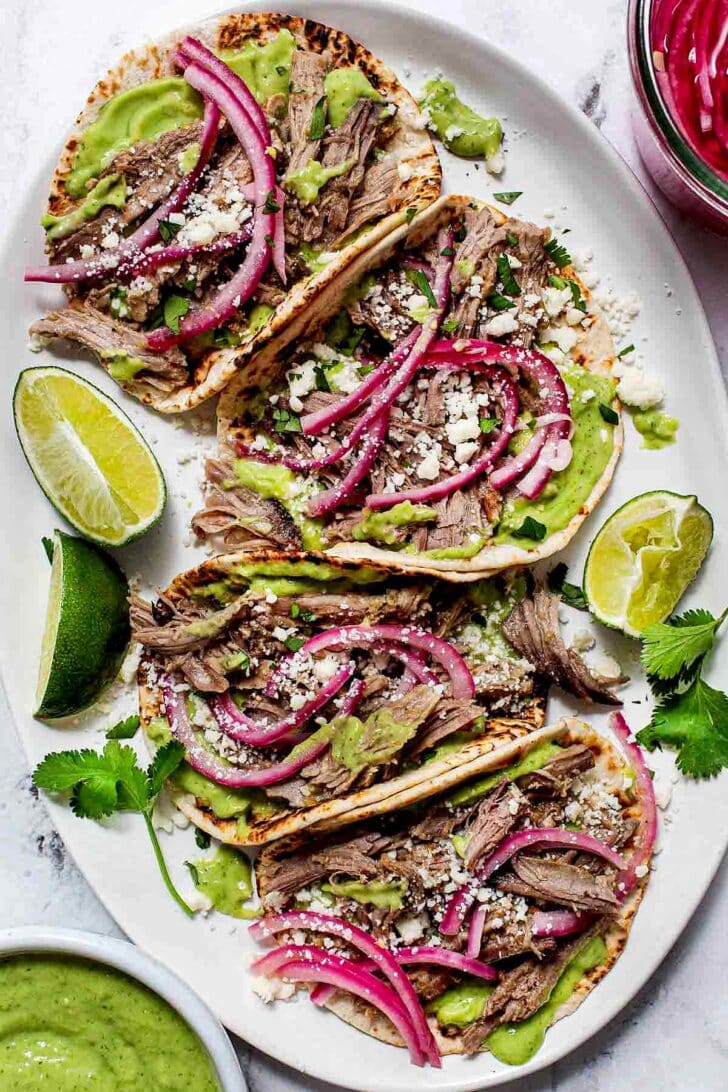 Salsa Verde Pork Tacos on platter with pickled onion