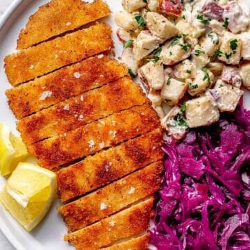 Chicken Schnitzel on plate with potato salad and sweet and sour red cabbage