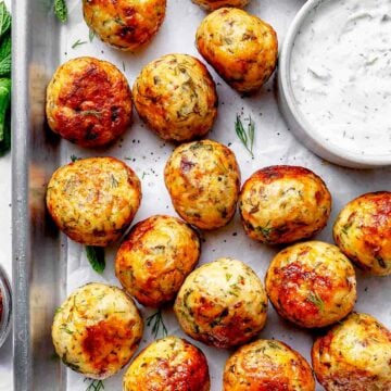 Mediterranean Chicken Meatballs on baking sheet with cucumber tzatziki