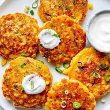 Corn Fritters recipe on platter with sour cream